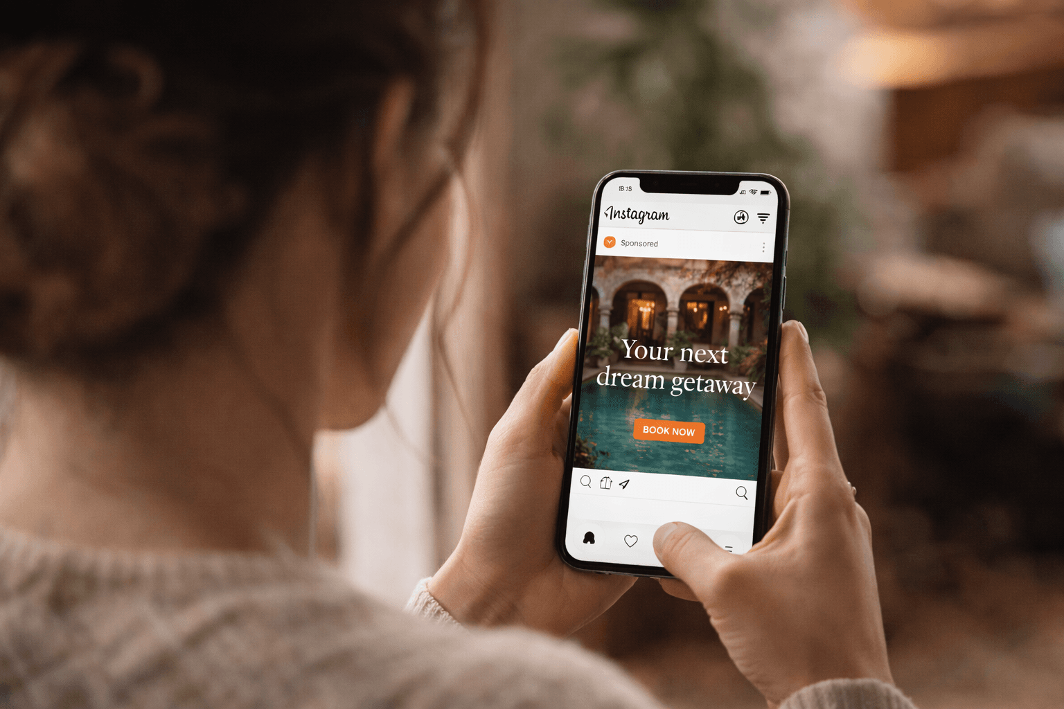 Woman holding a smartphone viewing a sponsored Instagram travel ad for a luxury dream getaway.